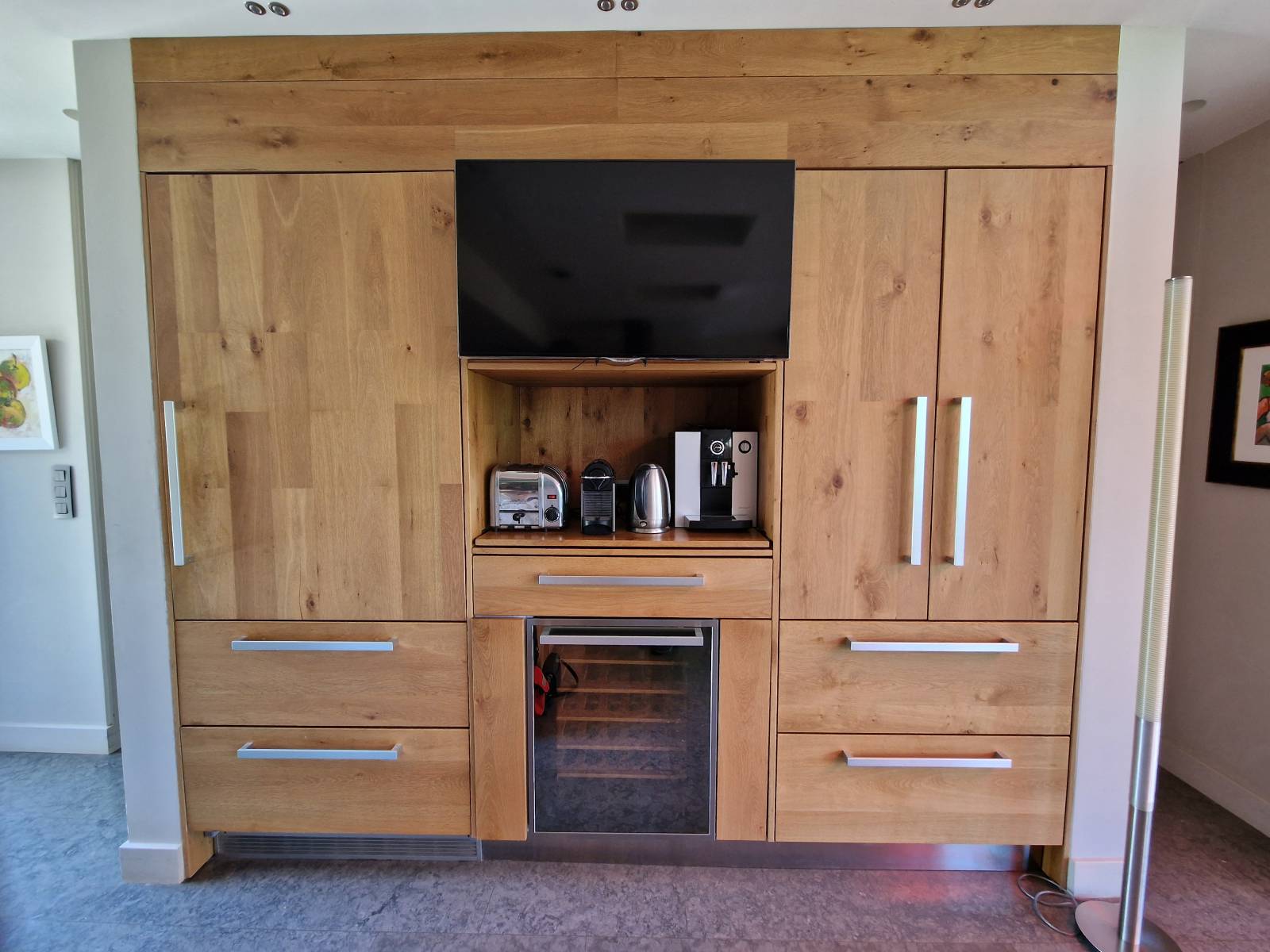 Agencement des colonnes pure bois avec un large frigo intégré et sa télévision 