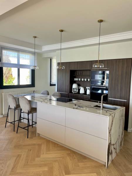 Bel ilot en céramique au coloris clair et cuisine en noyer