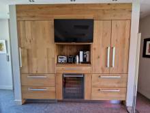 Agencement des colonnes pure bois avec un large frigo intégré et sa télévision 