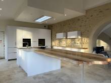 Table en bois naturel en prolongement de l'ilôt